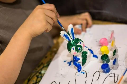 A child draws an Easter bunny in different colors Stock Photos