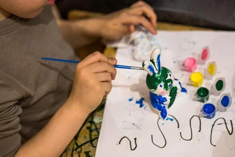 A child draws an Easter bunny in different colors Stock Photos
