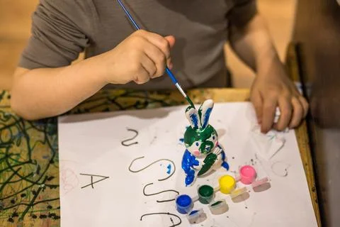 A child draws an Easter bunny in different colors Stock Photos