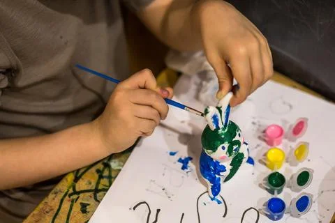 A child draws an Easter bunny in different colors Stock Photos