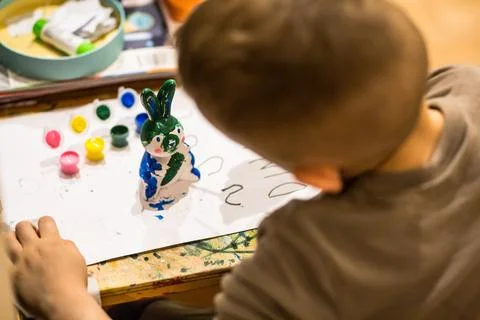 A child draws an Easter bunny in different colors Stock Photos