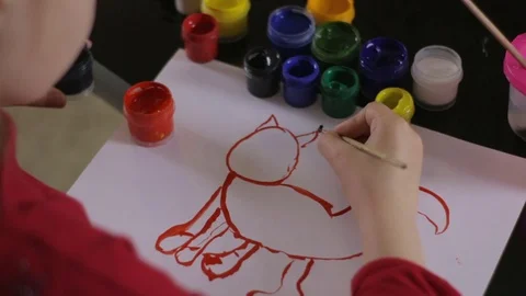 The child draws on paper with colors at the table Stock Footage 76194476