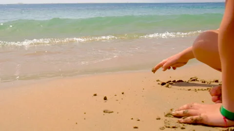 Child draws on the sand on the beach. selective focus. Stock Footage 154345422
