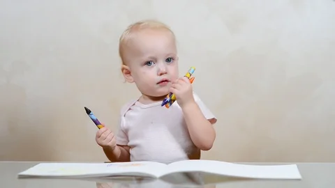 The child draws scribbles in the album and builds funny grimaces Video stock 118016328