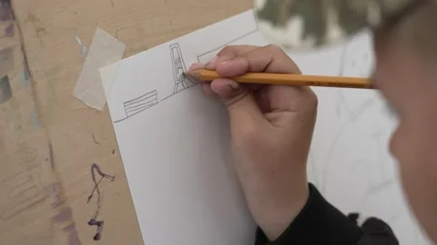 Child draws on a sheet with a pencil Stock Footage 160999411