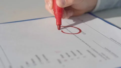 Child draws a smiley with a red marker on the document line Video stock 145628959