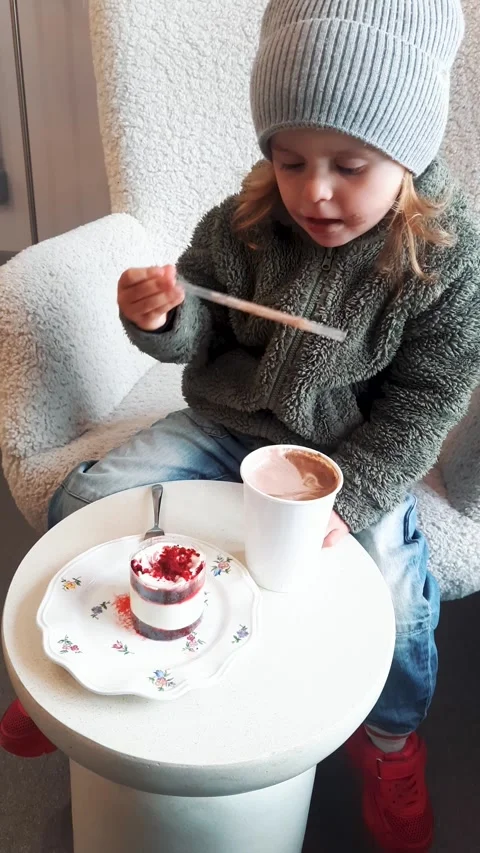 Child Drinking Cocoa with Dessert on Table Cozy Cafe Scene Video stock 332656760