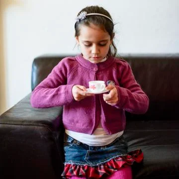 Child is drinking from the cup Stock Photos