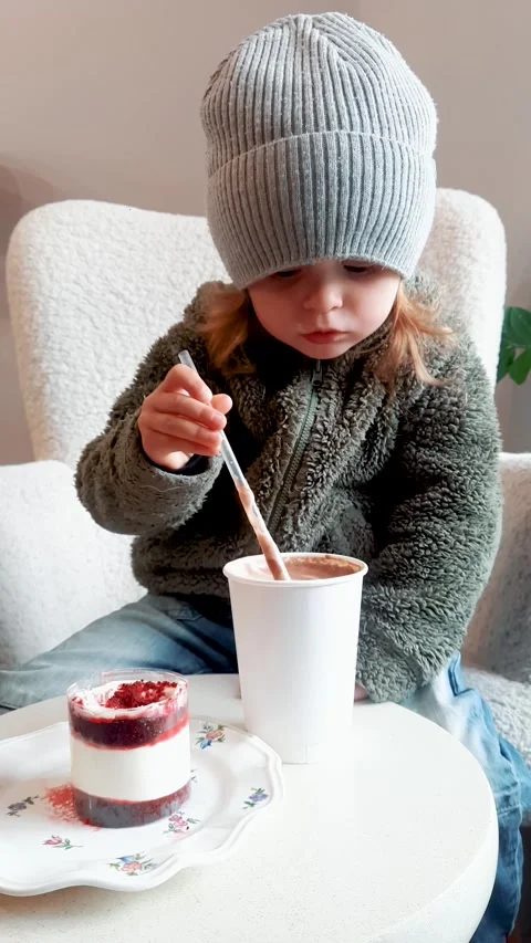Child Drinking Hot Cocoa in Cafe with Dessert Cake Видео 332656655