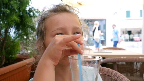 Child drinking lemonade with drinking straw at street cafeteria Stock-Footage 104824051