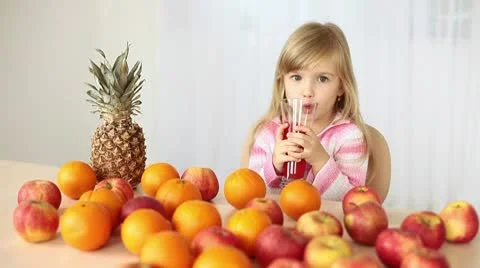 Child drinking orange juice at the table Video stock 10718131
