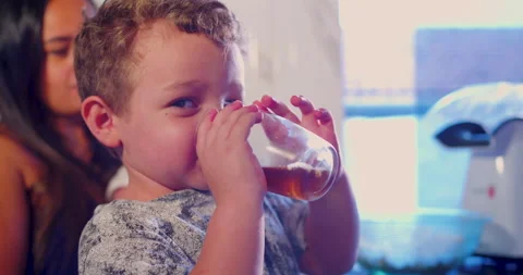 A child is drinking tea while waiting for the popcorn to be ready Stock-Footage 170731851