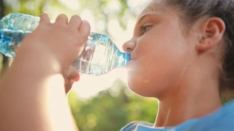 Child drinking water from a plastic bottle. water shortage problem on earth Video stock 237090681
