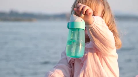 Child drinking water from plastic bottle. water shortage problem on earth Stock Footage 249925626