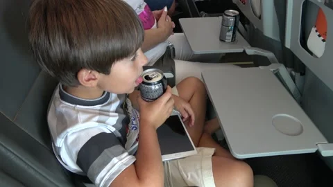 Child drinks from a can during his flight Stock Footage 140353047