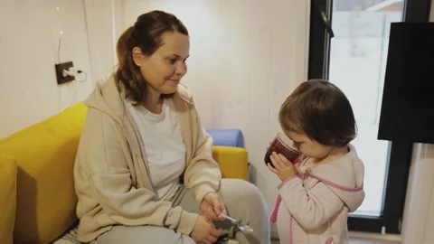 A child drinks compote next to his mother. In a cozy space, a loving interaction Stock Footage 311247790