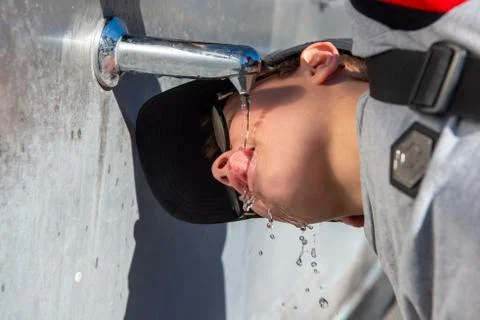 Child drinks from tap Stock Photos