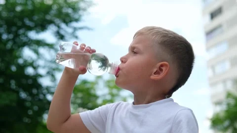 The child drinks water from a plastic bottle. Stock Footage 246500632