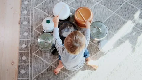 Child drummer having fun drum playing on kitchen pans at home Stock Footage 166530911