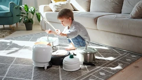 Child drummer having fun drum playing on kitchen pans at home Stock Footage 170191755
