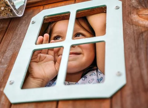 Child during the lockdown looking through the window Stock Photos