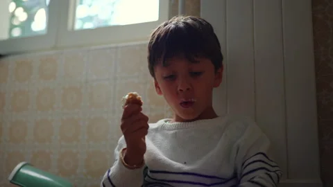 Child eating bread with soft cheese at home, candid childhood snack moment .. Stock Footage 342816142