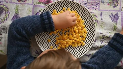 Child eating corn, top view Foto stock