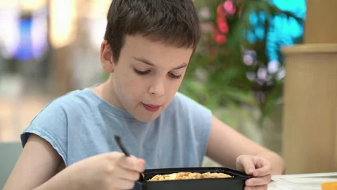Child eating fresh Caesar salad with chicken at a food court Stock-Footage 343160805