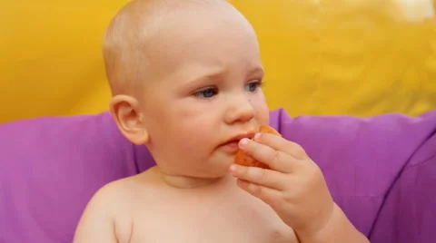 Child Eating Fruit Lying in an Easy Chair Stock Footage 64764706
