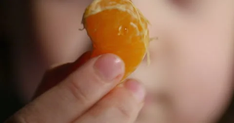 Child Eating Orange Slice, 4K Stock Footage 62733598
