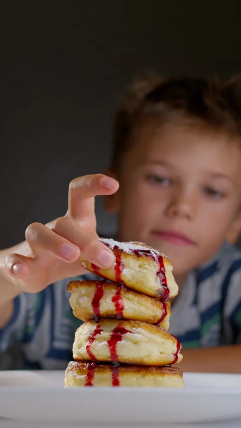Child eating pancakes with jam Stock Footage 314993724