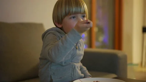 Child is eating while watching tv Stock Footage 146314054