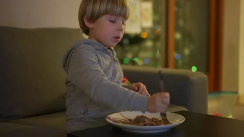 Child is eating while watching tv Stock Footage 146314297