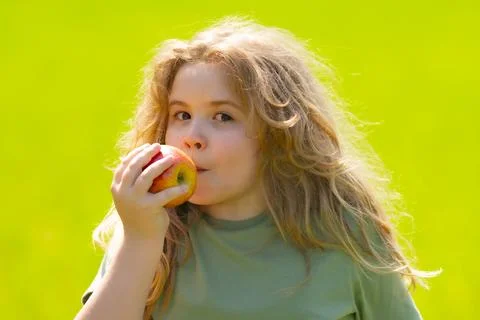 The child eats an apple. Ripe fruit for kids. Kid bites apple. The boy enjoys Stock Photos