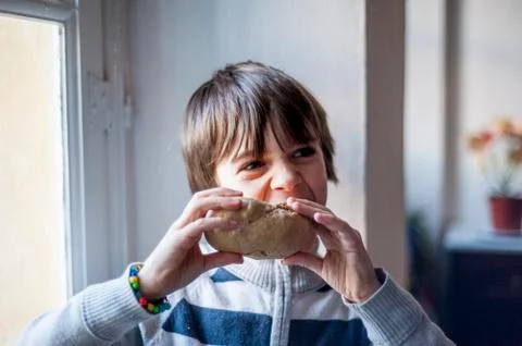 Child eats big homemade bread Stock Photos