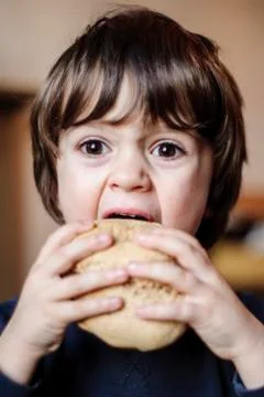 Child eats big homemade bread Foto stock