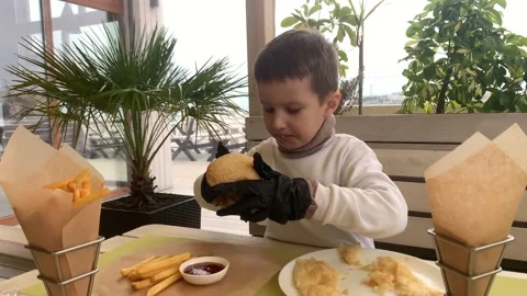 A child eats a big juicy hamburger Stock Footage 161938436