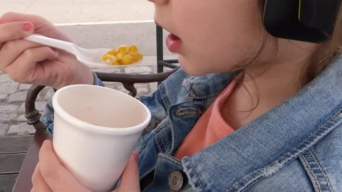 Child eats boiled corn in a cup. Stock Footage 130372030