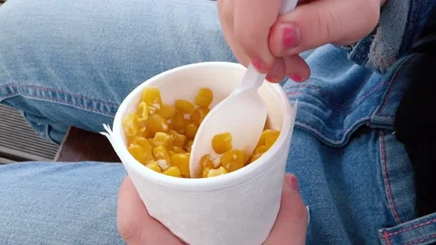 A child eats boiled corn in a glass. Stirring Close up Stock Footage 130371921