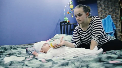 The child eats from a bottle. Spits out the milk and reaches for the bottle Stock Footage 102032004