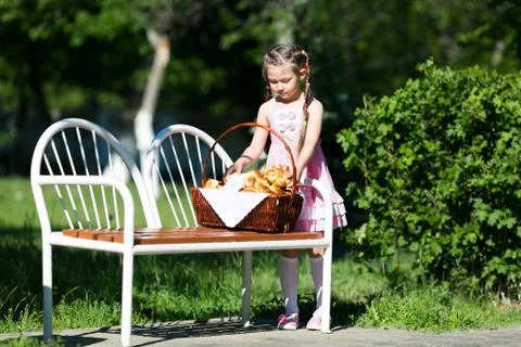 The child eats bread from a large basket. Foto stock