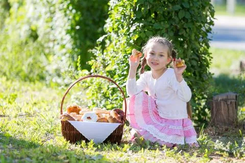 The child eats bread from a large basket. Foto stock