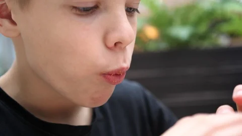 A child eats a bun with a cutlet and cheese in a fast food restaurant 스톡 동영상 107323466