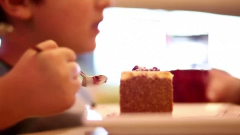 The child eats a cake and drinks juice through a straw Stock Footage 79393039