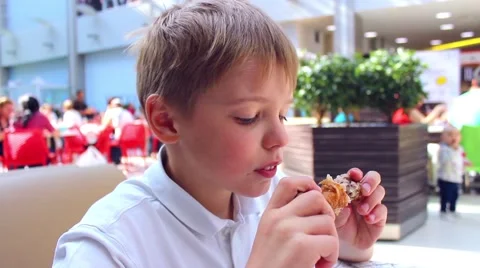 The child eats a chicken in a fast food 库存影片 64044219