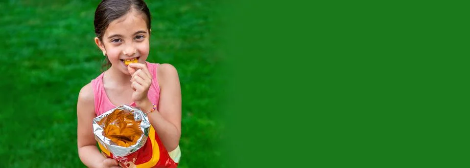 The child eats chips in the park. Selective focus. Stock-Fotos