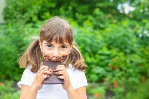 The child eats a chocolate bar. Selective focus. Stock Photos