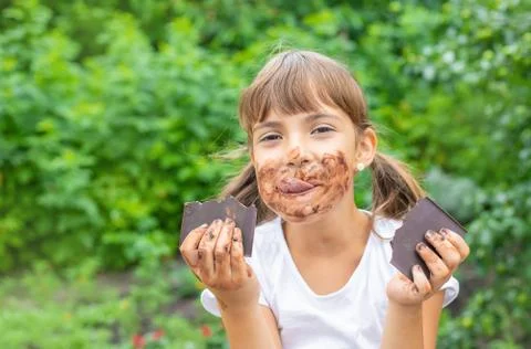 The child eats a chocolate bar. Selective focus. Stock-Fotos