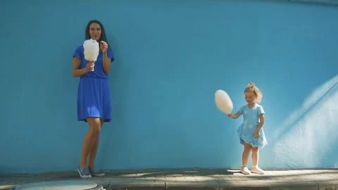 A child eats cotton wool with his mother on the streets of the city Stock Footage 93714935