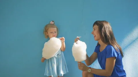 A child eats cotton wool with his aunt on the streets of the city Stock Footage 93715402